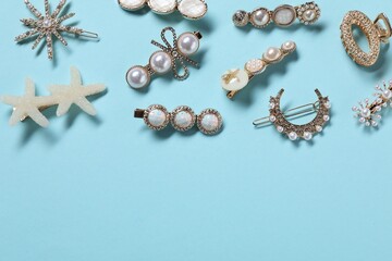 Different hair clips on light blue background, flat lay. Space for text