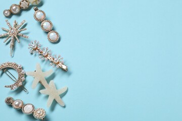 Different hair clips on light blue background, flat lay. Space for text