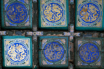 Close-up of ornate turquoise tiles featuring dragon designs brings the charm of ancient art at the Forbidden City in Beijing, China