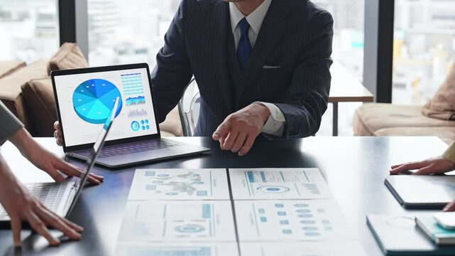 ビジネス、経営、マーケティング、ノートパソコン、グラフ、書類、提案、プレゼンテーション、チームワーク、企業、決算、戦略、マネジメント、経営者、社長、上司、部下、同僚、人材、指導、指示、ディレクション、コーチング、研修、リーダーシップ、経理、資料、レポート、企画書、データ、リサーチ、調査、レポート、画面、PC、IT、DX、オフィス、日本人、手元、顔なし、アップ、男性、商談、交渉、顧客、クライアント、