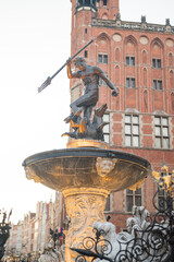 Neptune fountain in the European old town of Gdansk in the center in Poland with the town hall in...