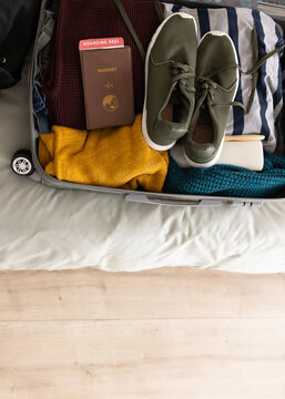 Packing suitcase with passport and boarding pass for travel adventure, at home, copy space