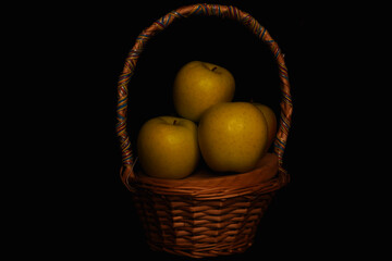 Basket of fruit (apples), taken with a dominance of lateral light that accentuates the shadows in an effect similar to chiaroscuro