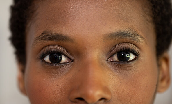 Close-up of African American woman's eyes, expressing confidence and focus, at home