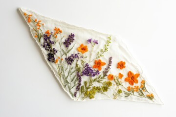 Delicate embroidered floral design on off-white fabric showcasing orange and purple wildflowers.