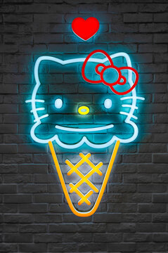 tokyo, ikebukuro - sep 09 2024: A vibrant Japanese neon sign featuring Hello Kitty's face created by Yuko Shimizu as an ice cream cone with a red heart above, photographed against a dark brick wall.