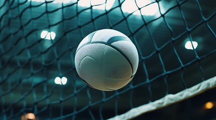 Focused close up of volleyball net and ball in bright indoor lighting image