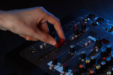 Woman working with professional mixing console at table, closeup