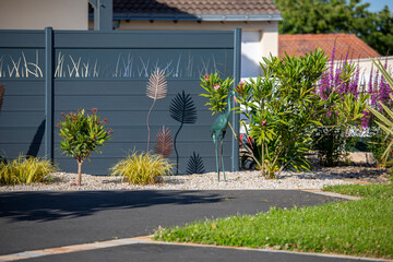 Naklejka premium Charmant petit jardin paysagé avec ses fleurs et ses plantes vertes au printemps.