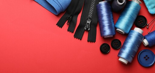 Different sewing supplies on red background, flat lay. Space for text