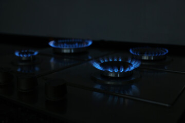 Gas burners with blue flame on stove, closeup
