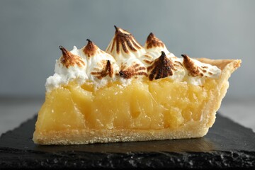 Piece of delicious pie with browned meringue on grey table, closeup