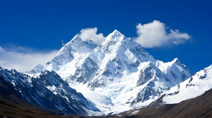 Fototapeta premium Majestic snow-capped mountain peak under a vibrant blue sky; background shows a high-altitude valley; ideal for travel, nature, or adventure brochures