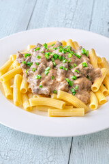 Beef stroganoff with rigatoni pasta, topped with fresh green onion garnish