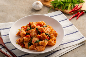 Stir Fried Thai bouncy pork meatballs (Pork patty) with holy Basil on white plate.