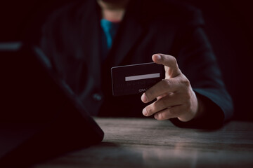 Online payment and digital transaction concept. Businessman holds a credit card in front of a...