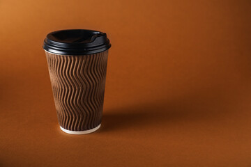 One paper cup on brown background. Mockup for design
