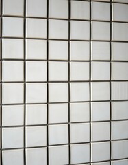 Close-up of a wall clad in square ceramic tiles, showcasing textured surface, geometric, background texture