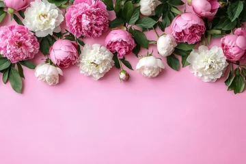 Pink and white peonies and roses on pastel pink background with copy space for romantic floral design