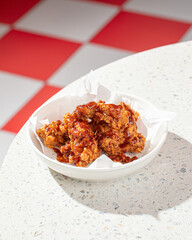 Portion of crispy fried boneless chicken thighs with red sauce