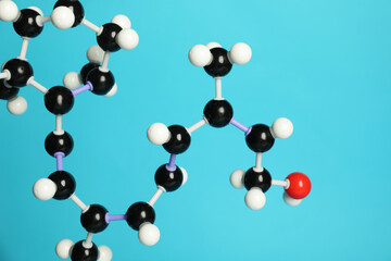 Molecule of retinol (vitamin A) on light blue background, closeup. Chemical model