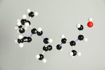 Molecule of retinol (vitamin A) on light grey background. Chemical model