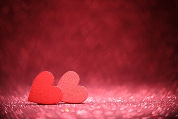 Romantic decor. Wooden hearts on shiny pink glitter and heart shaped lights, space for text. Bokeh effect