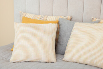 Soft decorative pillows on bed in bedroom