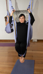 woman doing aerial yoga exercise