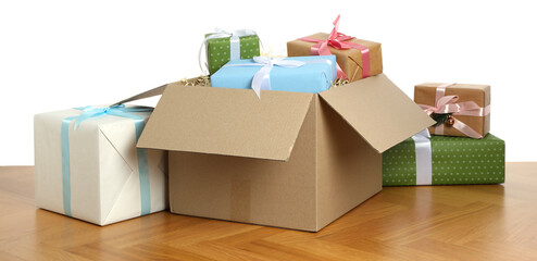 Parcel with gift boxes on wooden table against white background