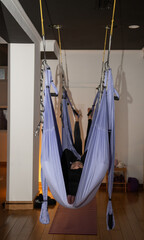 Woman relaxing in aerial yoga class