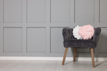Soft decorative pillows on armchair in room. Space for text