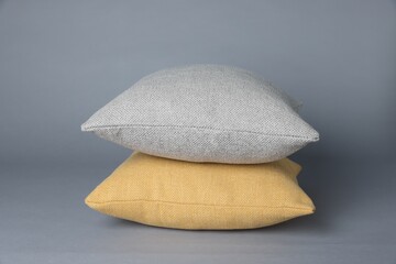Two soft decorative pillows on grey background
