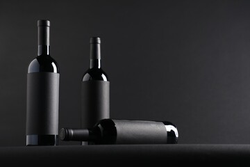 Bottles of wine on black background, space for text