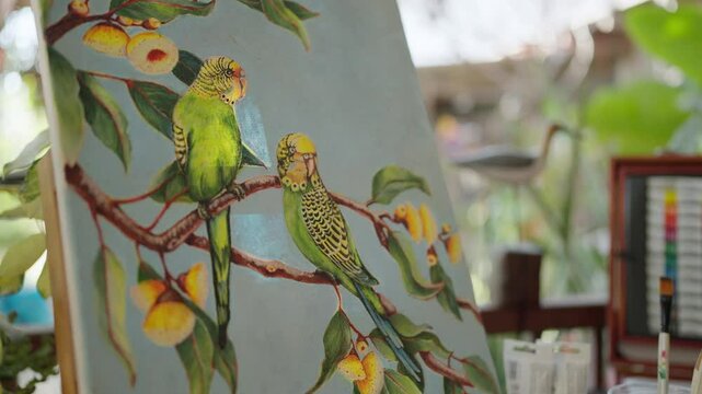 Exquisite hand painted watercolor of a lively bird on canvases on an wooden easel. Showcasing nature inspired artwork. Artist painting concept
