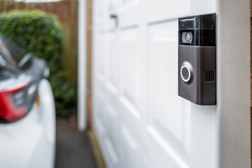 Shallow focus of a popular, battery powered wireless doorbell and integral camera seen located on a...