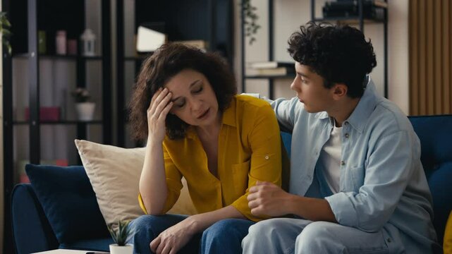 Caring teen son comforting his upset mother, showing trust and emotional support