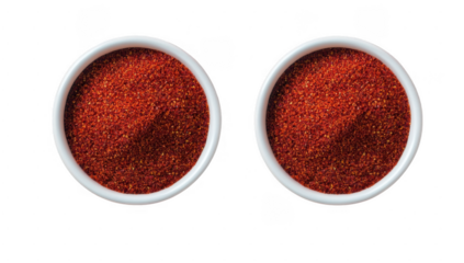 two small white bowls filled with a vibrant red spice showcasing a fine texture and a mound shape suggesting a culinary use for flavoring or seasoning dishes