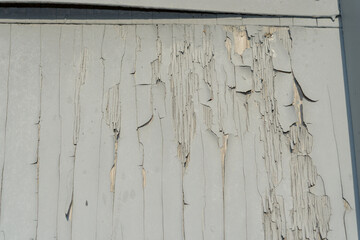 painted door surface with cracked and peeling gray paint