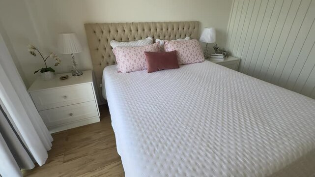 quarto com cama arrumada branco e rosa 