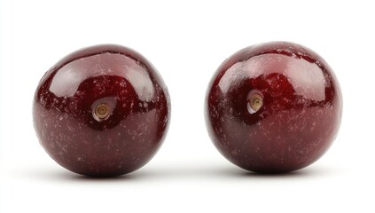 Obraz premium Two vibrant, round plums, isolated on white. Close-up view highlighting their deep red color and glossy texture