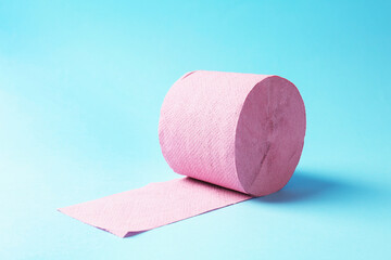Pink toilet paper roll on light blue background
