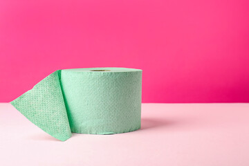 Green toilet paper roll on pink background. Space for text