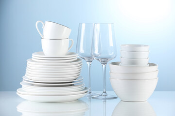 Different clean dishware on light blue background