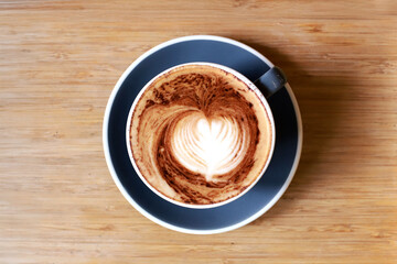 Top view of hot latte coffee with latte art in the gray cup on wooden table,close up cup of coffee
