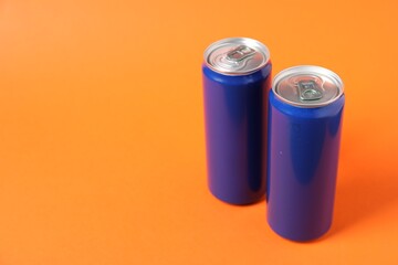 Two tin cans on orange background. Space for text