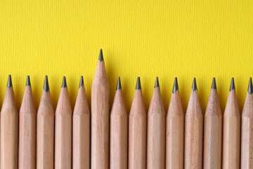 Many pencils on yellow background, top view. Space for text