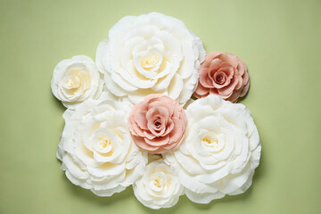 Beautiful paper flowers on light green background, flat lay