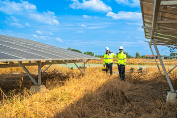 Team engineers in a high visibility jacket performs an inspection on the underside of a solar panel...