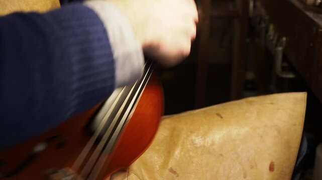 Luthier polishing violin tuning pegs in his workshop